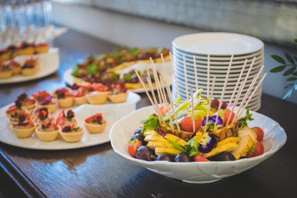 A beautifully arranged platter of fruit and desserts on a dining table, perfect for events.